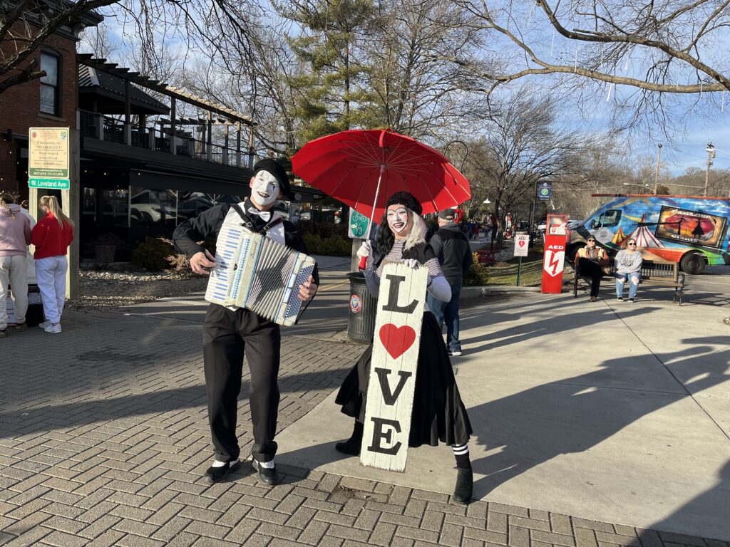 Mimes dressed in valentine outfits with umbrella and accordian